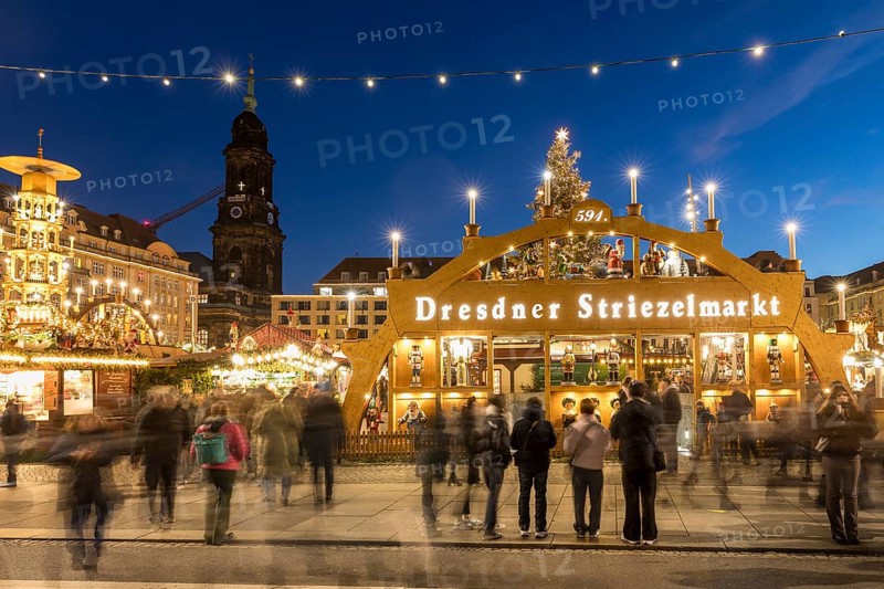 Large walk-in light arch at the entrance to Striezelmarkt, Germany's oldest Christmas market, with the Kreuzkirche tower in the background, Dresden, Saxony, Germany
