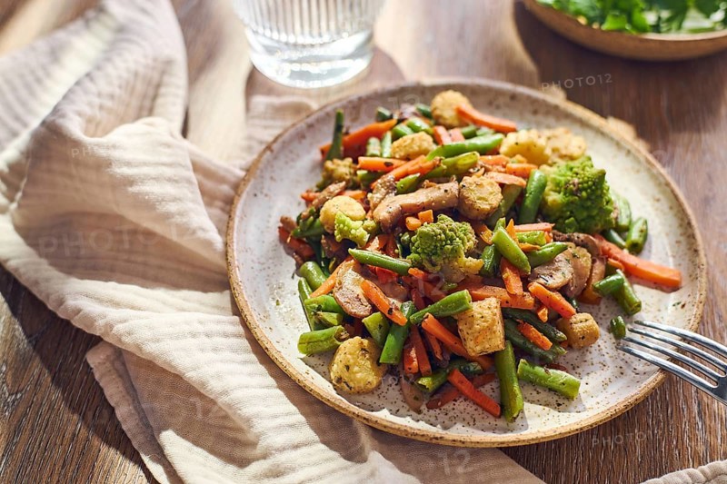 Plate of stir-fried mixed vegetables with green beans, carrots, baby corn, romanesco and mushrooms