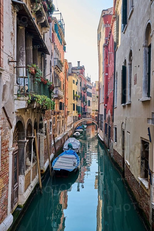 View on a waterway with boats lying in the water in Venice on a sunny day in winter, Italy
