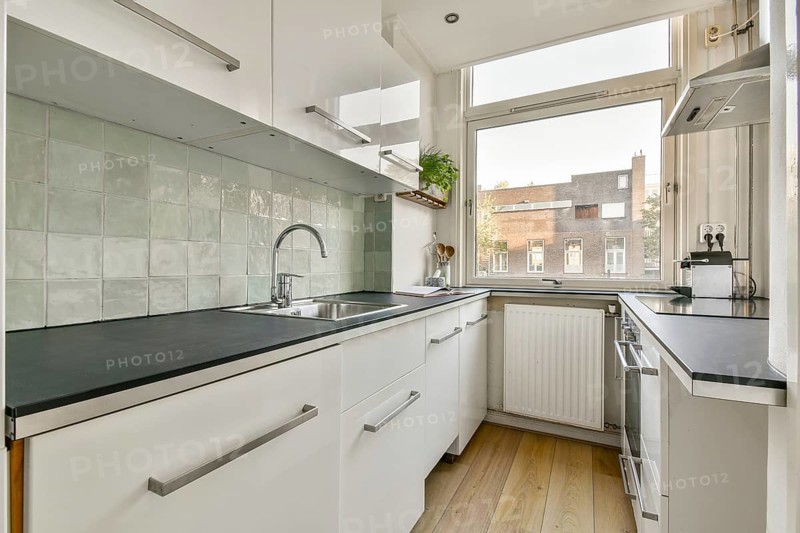 A sleek and contemporary kitchen featuring a minimalist design, equipped with modern appliances and a clean, organized workspace