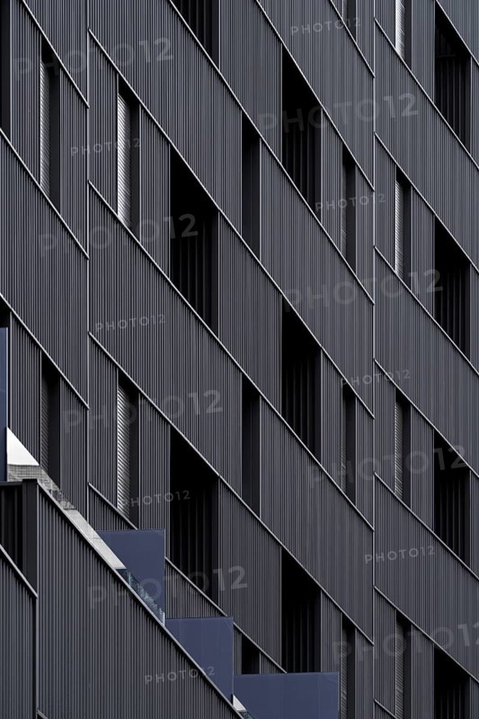 Sustainable modern architecture with building showcasing eco-friendly design elements such as energy efficient structures and low emission materials. The facade's geometry highlights passive house standards contributing to environmental conservation