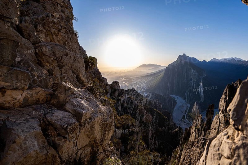 A breathtaking sunrise view from Eagle's Nest in Monterrey, Mexico. The rugged rock formations frame the city skyline and surrounding mountains, creating a picturesque landscape