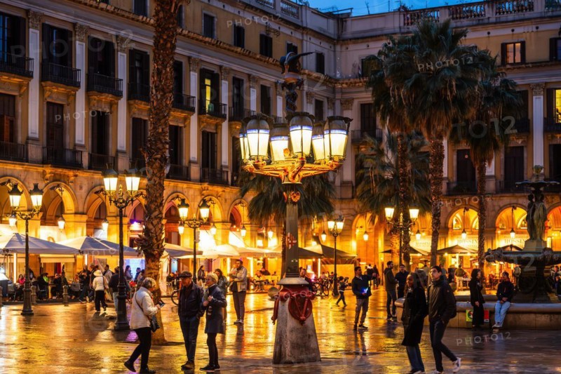 Nightlife at Plaça Reial, lanterns by Gaudi in the historic centre of Barcelona, Spain