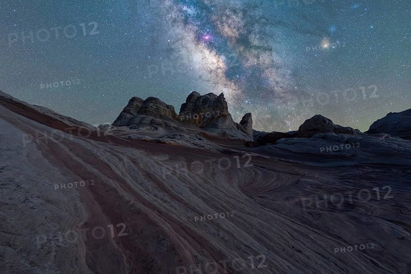 Vivid Milky Way illuminates the striped rock formations in the Utah desert under a starry sky