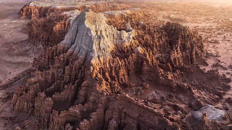 Stunning aerial photograph captures the intricate, erosion-sculpted rock formations of Goblin Valley State Park in Utah, USA, bathed in the warm glow of a sunset