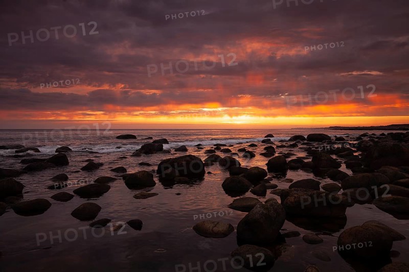 Rocky bay under a dramatic glowing sky at the coast. unset, Vigrestad, Rogaland, Norway