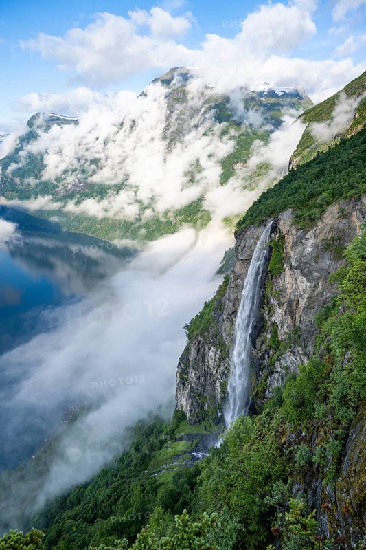Gjerdefossen waterfall, at Ørnesvingen viewpoint, atmospheric clouds over the fjord in the morning light, at Geirangerfjord, near Geiranger, Møre og Romsdal, Norway