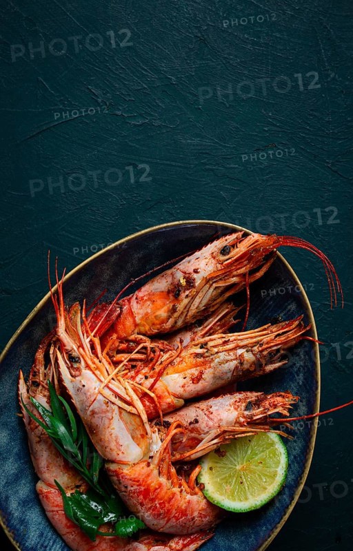Langoustines, Australian, freshly frozen on ice, top view, lime and greens