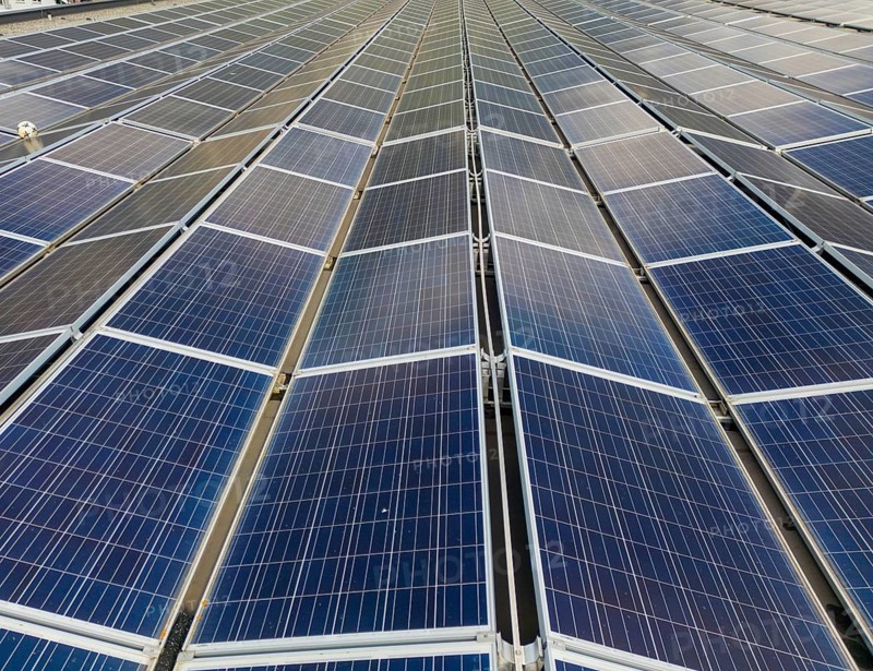 Aerial photo of expansive solar panels in Switzerland, capturing renewable energy under a clear sky. The sustainable energy solution highlights a green future