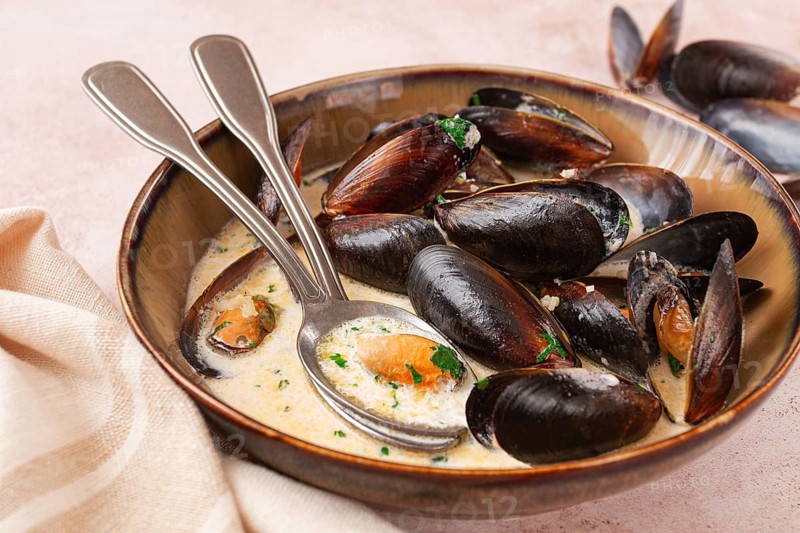 Mussels in creamy garlic sauce, served with fresh herbs and spices, homemade, no people
