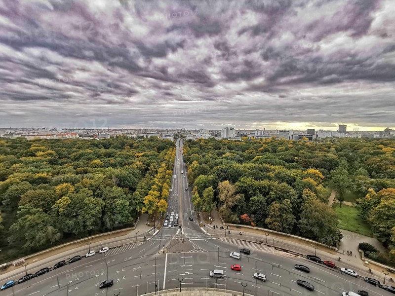 View from Victory Column, A dramatic cloudy sky over Berlin with a long avenue flanked by autumn trees, Berlin