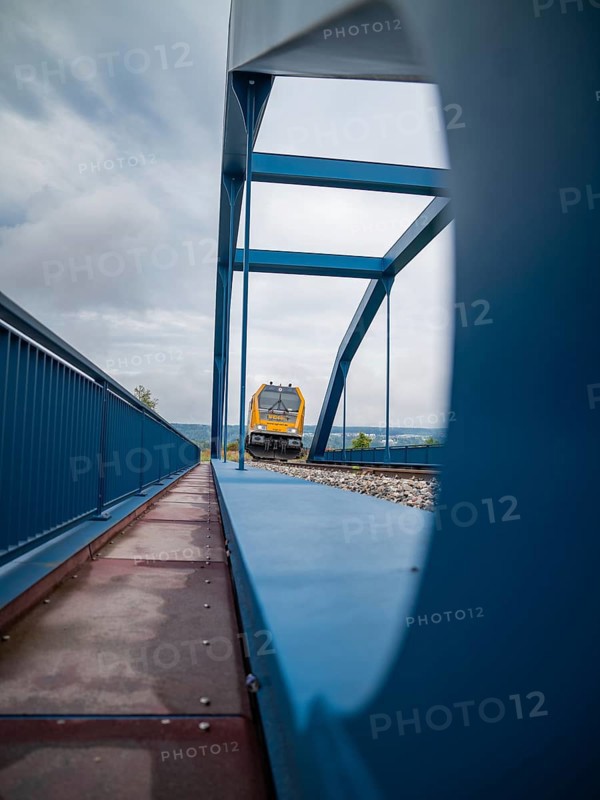 Yellow train through steel bridge taken from an unusual angle, track construction, rail delivery for Hermann Hessebahn, Calw, Black Forest, Germany