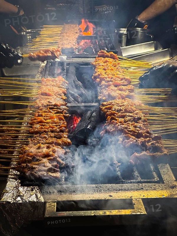 Satay, Asian food, dish which is seasoned, skewered and grilled meat over hot burning charcoal on a large satay BBQ. Delicious tasty Asian street food served with sauce for lunch or dinner. Singapore