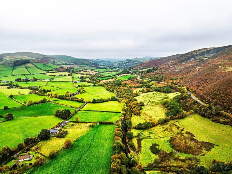 Autumn colours of Farms over River Wye and Road A470 from a drone, Llanidloes, Powys, Montgomeryshire, Wales, UK