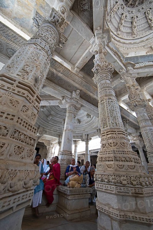 Indian woman praying between the white marble pillars in the Adinath temple in Ranakpur, Jain temple, Rajasthan, India
