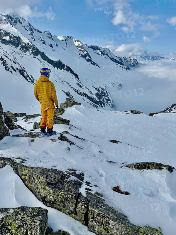 Skier enjoying the view of a valley with clouds, mountain scenery in winter, Fellilucke, Glarner Alps, Grisons, Switzerland