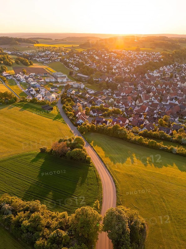 View of a village and a road surrounded by fields and trees at sunset, Gechingen, Black Forest, Germany