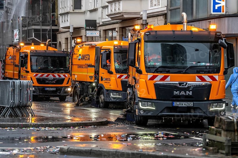 Sweeping on Rose Monday in Düsseldorf, the municipal utilities clean up after the train, confetti, camels, trash, employees with sweepers from AWISTA, Society for Waste Management and City Cleaning, central disposal and urban cleaning companies in Düsseldorf, clean the train's path with their street cleaning machines, North Rhine-Westphalia, Germany