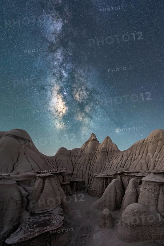 A breathtaking night sky filled with the Milky Way stretches above the unique, weathered rock formations in Utah, USA