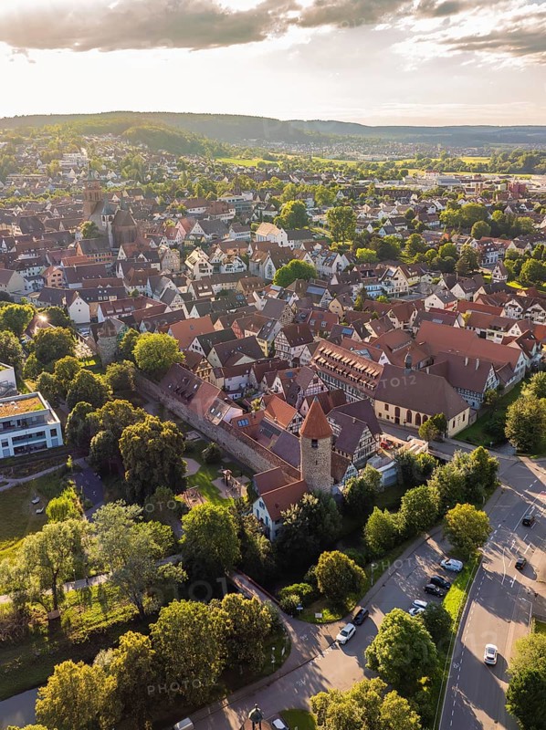 View of a historic old town with dense roofs, towers and surrounded by green trees and streets, Weil der Stadt, Germany