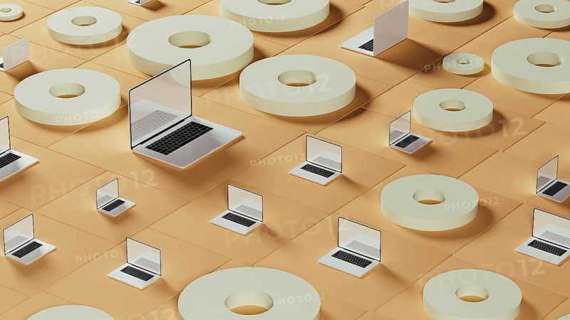 This setting displays numerous laptops arranged among circular tiles on a smooth surface, highlighting technology's abstract nature