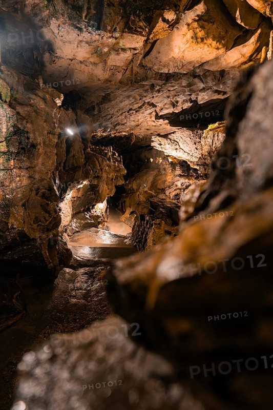 A mysterious cave trail with dramatic lighting and rock formations, St. Beatus Caves, Switzerland