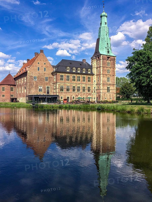 View over moat on moated castle Raesfeld, below reflection on water surface, Hohe Mark nature park Park, Münsterland, North Rhine-Westphalia, Germany