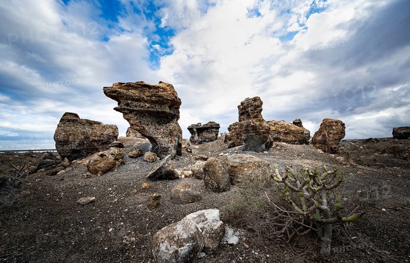 Eroded rock formations in volcanic landscape with dramatic cloudy skies, Ciudad Estratificada or Los Roferos, Antigua Rofera de Teseguite, Lanzarote, Canary Islands, Spain