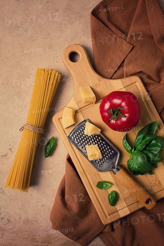 Raw pasta with ingredients on a beige background, top view, rustic style, selective focus, no people.
