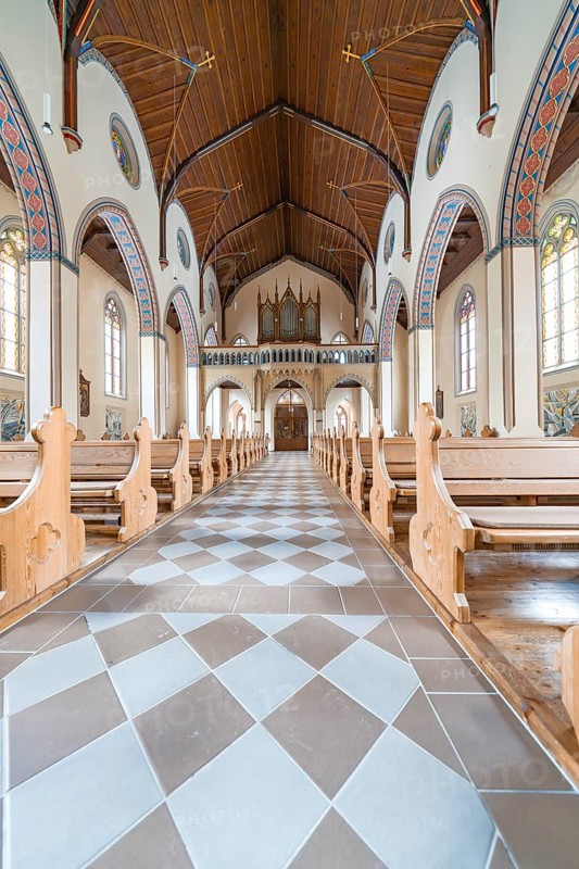 Long aisle in a church with elegant wooden benches and artistically decorated structure, Bad Wildbad, St.Bonifatius, Catholic parish, Black Forest, Germany
