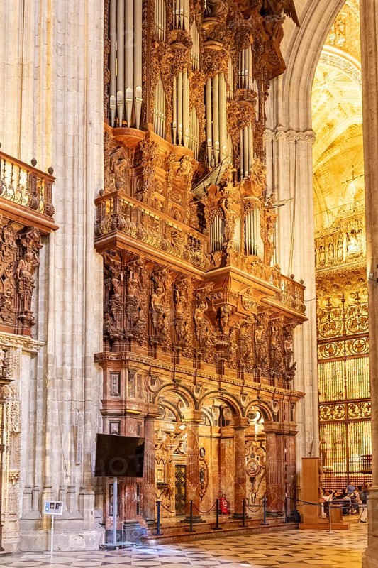 Magnificent organ in the interior of a cathedral with ornate decorations, Seville