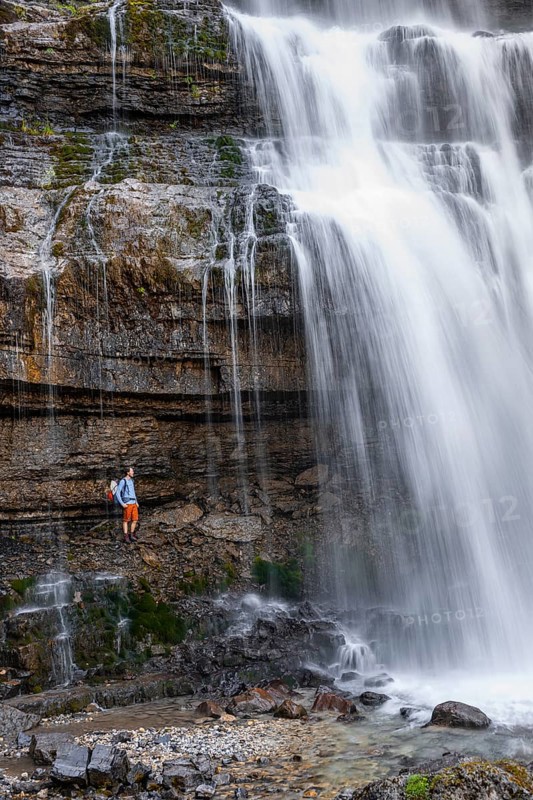 Little hiker in front of large Cascata di Mezzo waterfall, long exposure, Vallesinella, Brenta, Trentino, Italy