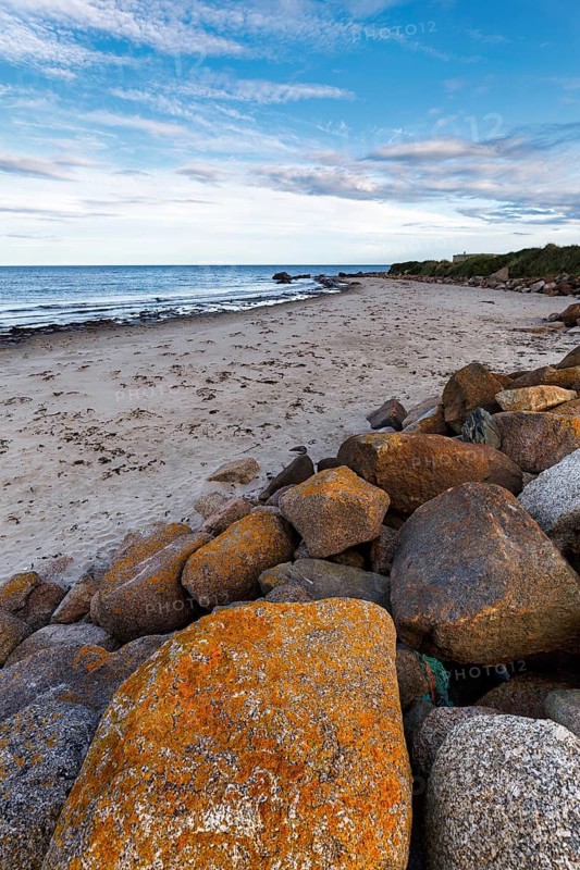 Coastal defence, boulders with view on sandy beach, dusk, Carne Beach, Wexford, Gerrans Bay, Roseland Peninsula, Ireland