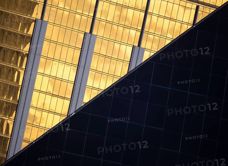 A visually striking composition of modern architecture in Las Vegas. The image features contrasting textures and colors, with reflective gold and sleek dark surfaces