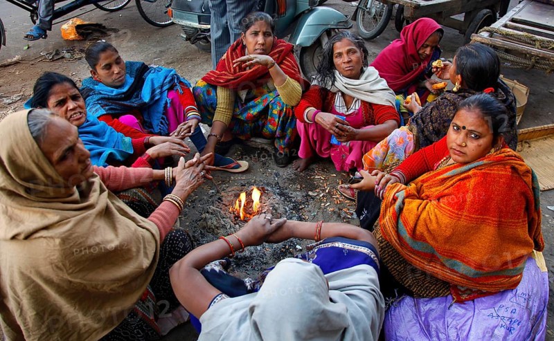 New Delhi, India, 15.01.10 - Women warm up by a fire at the market in New Delhi, India