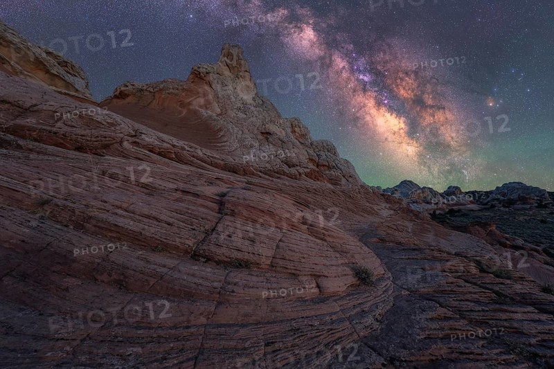 Stunning nightscape of the Milky Way over the unique rock formations in White Pocket, Arizona, USA. The scene captures the serene beauty of the desert under starry skies