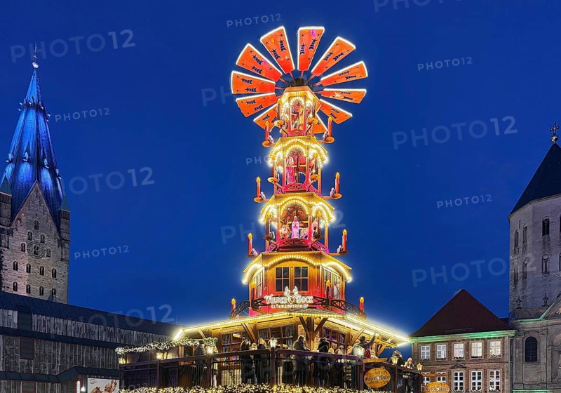 Christmas market with mulled wine pyramid on the market with St. Ulrich Cathedral and Gaukirche in the evening, Paderborn, North Rhine-Westphalia, Germany