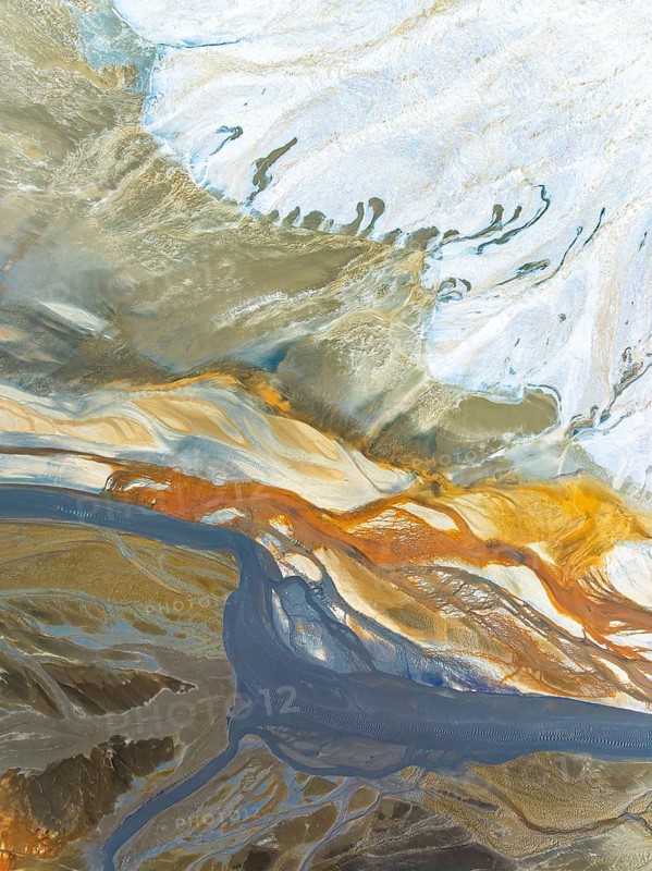 Top view aerial shot capturing the enticing swirls and organic patterns formed by natural elements. The dynamic array of colors and textures offers a unique perspective on the landscape's beauty