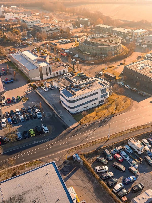 Aerial view of an urban industrial area with buildings and car parks under an orange sky, Gültstein, Herrenberg, Germany
