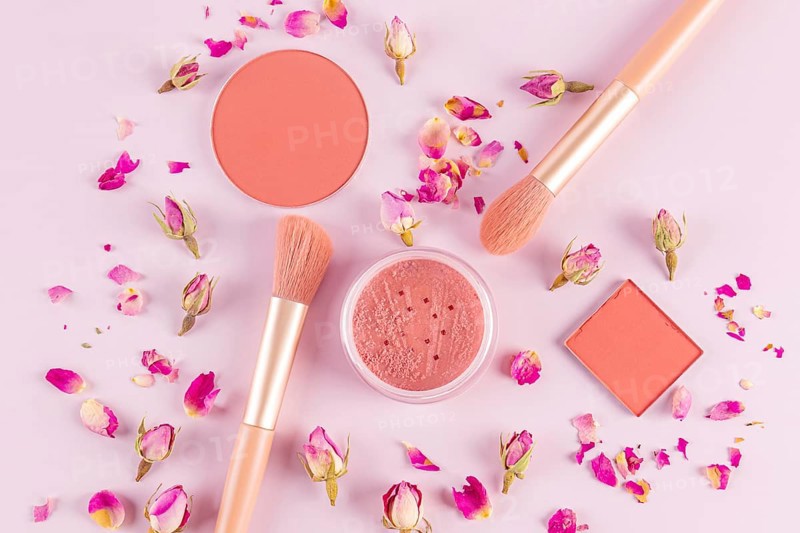Aesthetic flat lay of pink makeup brushes and cosmetics surrounded by delicate rose petals on a light background Perfect for beauty and fashion-related projects