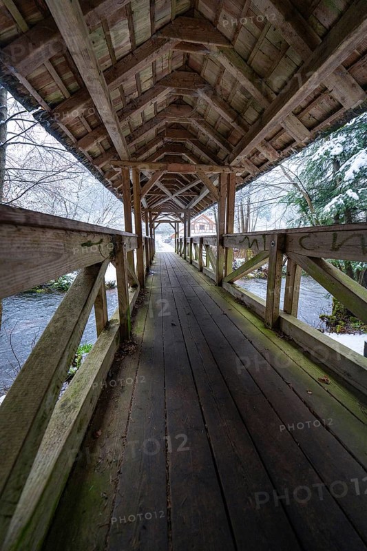 Long walkway of a wooden bridge over a wintry river course, Kälberbrücke, Enzklösterle, Calw district, Black Forest, Germany