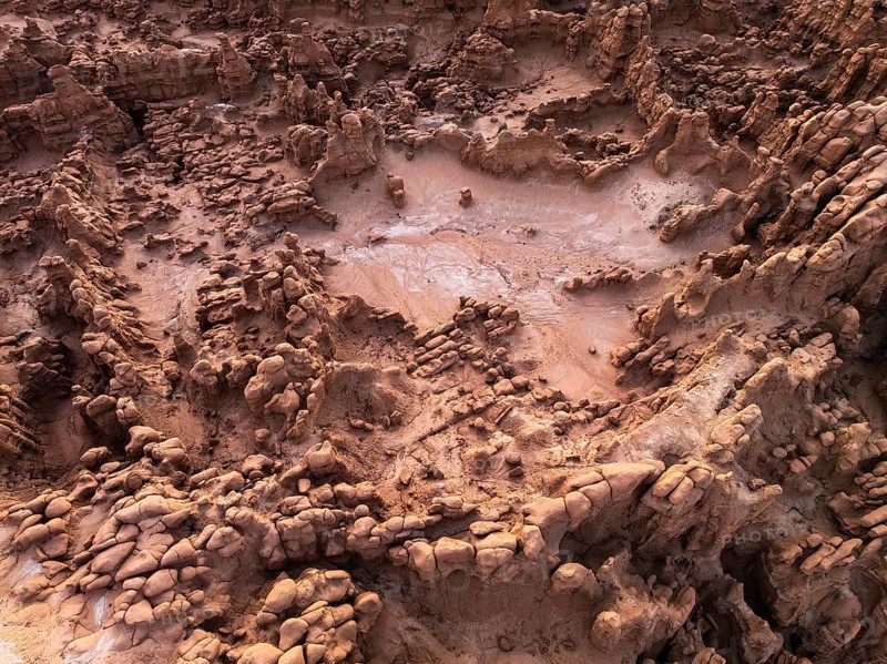 A captivating aerial shot of the textured, rocky formations at Goblin Valley State Park, Utah, showcasing erosion patterns and sediment layers