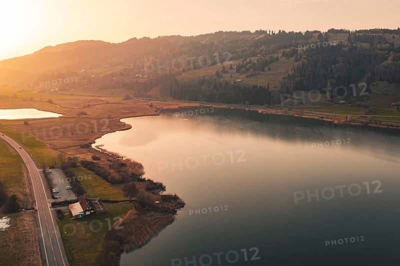 Valley with quiet lake and surrounding landscape in the warm light of sunset, Großer Alpsee, Immenstadt im Allgäu, Bavaria, Germany