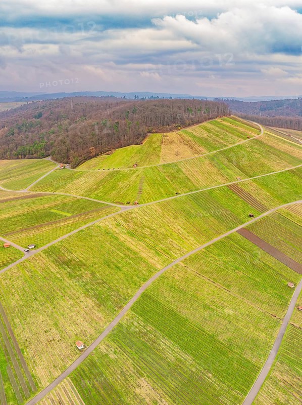 Aerial view of green fields and roads in hilly terrain under a cloudy sky, Großbottwar, Ludwigsburg district, Baden-Württemberg, Germany