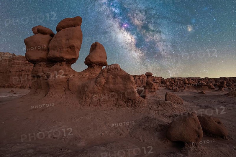 Captivating view of the Milky Way galaxy shining brightly over the unique hoodoo rock formations of Goblin Valley State Park in Utah, presenting a stunning night landscape