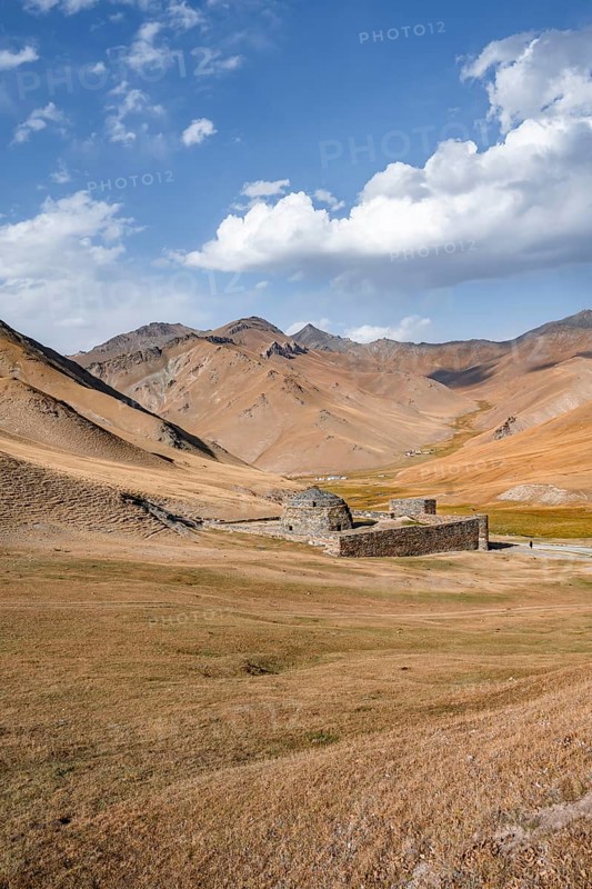 Historic caravanserai Tash Rabat from the 15th century, with yellow hills, Atbashy district in the Naryn region, Kyrgyzstan