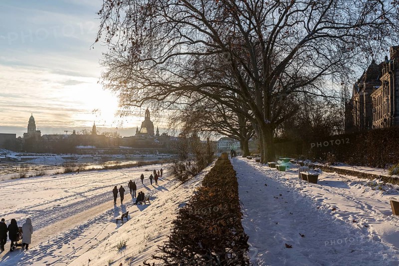 Sunny winter weather and drift ice on the Elbe attract many walkers to the Neustädter Elbe bank, with the Church of Our Lady in the background, Dresden, Saxony, Germany