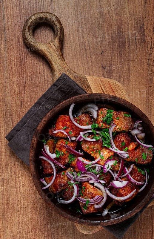 Fried meat, pork kebab, ketsi in a clay pan, with red onions and herbs, homemade, no people