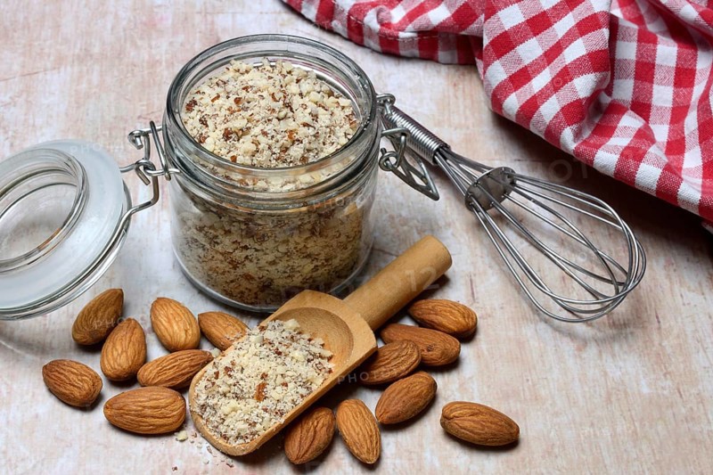 Almonds and ground almonds in glass, Prunus amygdalus