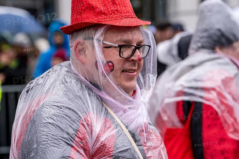 Rose Monday procession in Düsseldorf, parade participants, foot groups, make themselves rainproof, at street carnival, sometimes heavy rain, North Rhine-Westphalia, Germany